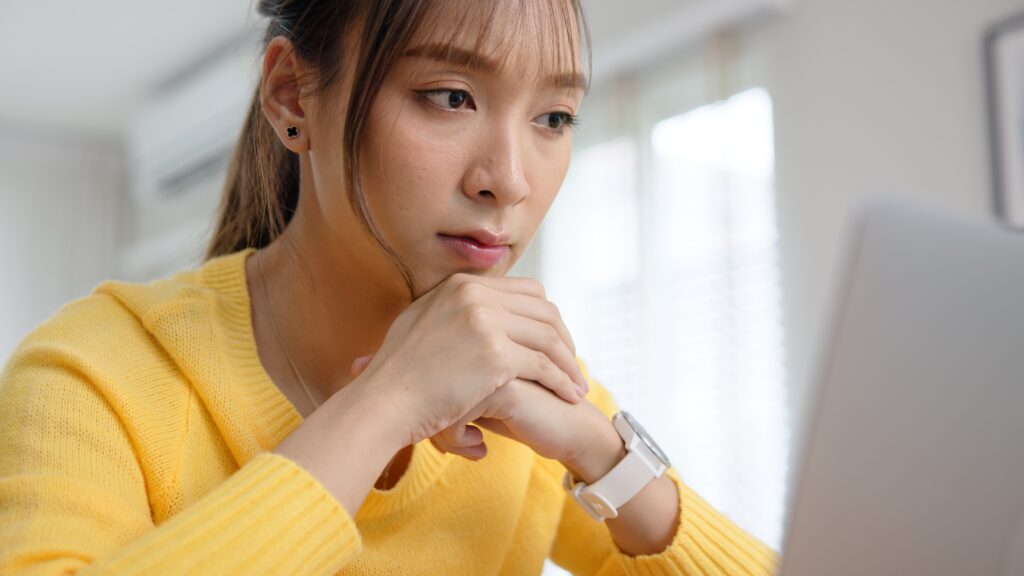 A woman in front of a laptop showcasing mental toughness at work.